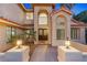 Inviting front entrance with a grand arched window, double doors, decorative lighting, and lush landscaping at 1990 Freeman Ct, Henderson, NV 89014