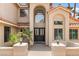 Elegant home entrance with a tiled roof, double doors, manicured landscaping, and stylish lighting at 1990 Freeman Ct, Henderson, NV 89014