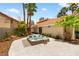 Backyard featuring a relaxing hot tub with seating, palm trees, and stucco exterior at 1990 Freeman Ct, Henderson, NV 89014