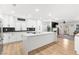 A bright, modern kitchen featuring an island, white cabinets, stainless steel appliances, and updated lighting fixtures at 1990 Freeman Ct, Henderson, NV 89014