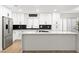 A modern, stylish kitchen with white cabinets, stainless steel appliances, an island, and black tiled backsplash at 1990 Freeman Ct, Henderson, NV 89014