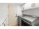 Bright laundry room features modern washer and dryer, white cabinets, and a convenient access door at 1990 Freeman Ct, Henderson, NV 89014