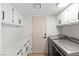 Bright laundry room features modern washer and dryer, white cabinets, and a convenient access door at 1990 Freeman Ct, Henderson, NV 89014