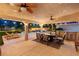 Relaxing covered patio with outdoor kitchen, dining area, ceiling fans, and backyard views at 1990 Freeman Ct, Henderson, NV 89014