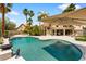 Stunning pool featuring unique shape, baja step, and mature desert landscaping at 1990 Freeman Ct, Henderson, NV 89014