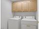 Convenient laundry area with overhead cabinets and a stacked washer and dryer at 2149 Eaglepath Cir, Henderson, NV 89074
