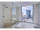 Modern bathroom features a soaking tub, separate shower with bench, and city views at 222 Karen Ave # 2308, Las Vegas, NV 89109