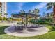 Outdoor seating area with modern chairs and tables under a shaded structure, surrounded by lush landscaping at 222 Karen Ave # 2308, Las Vegas, NV 89109
