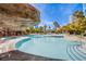 Gorgeous community pool area with rock features and palm trees under a bright blue summer sky at 222 Karen Ave # 2308, Las Vegas, NV 89109