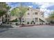 Inviting two-story condo featuring a stucco exterior, private balconies, and lush landscaping under a partly cloudy sky at 2251 Wigwam Pkwy # 716, Henderson, NV 89074