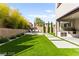 Spacious backyard has artificial turf, lush plantings and a covered patio at 2407 Ridgeline Wash St, Las Vegas, NV 89138