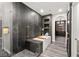 Modern bathroom featuring a soaking tub with decorative wood accents and dark grey stone tiling at 2407 Ridgeline Wash St, Las Vegas, NV 89138