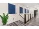 Bright hallway featuring gray wood floors, a modern railing, and several blue-shade windows for natural light at 2407 Ridgeline Wash St, Las Vegas, NV 89138