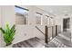 Bright hallway featuring gray wood floors, a modern railing, and several windows for natural light at 2407 Ridgeline Wash St, Las Vegas, NV 89138