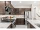 Well-equipped kitchen features stainless steel appliances, dark cabinetry, quartz countertops, and sleek gas range at 2407 Ridgeline Wash St, Las Vegas, NV 89138