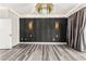 Spacious living room features gray wood floors, a decorative black wall, modern lighting and balcony access at 2407 Ridgeline Wash St, Las Vegas, NV 89138