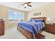 Cozy bedroom with a wooden bed frame, blue striped bedding, and an abundance of natural light from the window at 2555 Hampton Rd # 7304, Henderson, NV 89052