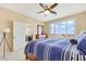 Bright bedroom featuring a ceiling fan, large window with shutters, and a comfortable blue striped quilt at 2555 Hampton Rd # 7304, Henderson, NV 89052