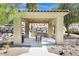 An outdoor kitchen with a grill nestled within manicured landscaping and a stone backdrop at 2555 Hampton Rd # 7304, Henderson, NV 89052