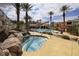 Community pool and hot tub surrounded by palm trees and lounge chairs on a sunny day at 2555 Hampton Rd # 7304, Henderson, NV 89052