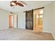 Bedroom with rustic barn door leading to an en-suite bathroom with tile shower at 2614 Capistrano Ave, Las Vegas, NV 89121