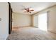 Bright bedroom featuring plush carpeting, ceiling fan, and sliding glass doors for natural light at 2614 Capistrano Ave, Las Vegas, NV 89121