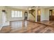 Bright living room with hardwood floors, a fireplace, large window, and staircase at 2614 Capistrano Ave, Las Vegas, NV 89121