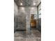 This shower features double shower heads and grey stone tiled walls at 2695 Ponte Vecchio Ter, Henderson, NV 89052