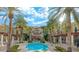 Beautiful pool area surrounded by lush palm trees and attractive resort-style buildings at 30 Strada Di Villaggio # 429, Henderson, NV 89011
