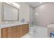 Stylish bathroom with wooden vanity, white countertop, soaking tub, and glass shower door at 3104 Conners Dr, Las Vegas, NV 89107