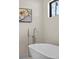 Freestanding soaking tub with modern fixtures, framed artwork, and black trim window at 3104 Conners Dr, Las Vegas, NV 89107