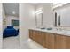 Elegant bathroom with modern double vanity, wood cabinetry, and views into bedroom at 3104 Conners Dr, Las Vegas, NV 89107