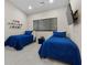 Comfortable bedroom featuring two twin beds with blue bedding and a wall-mounted television at 3104 Conners Dr, Las Vegas, NV 89107
