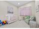 Charming Bedroom with a white crib, comfortable chair, and soft pastel decor at 3104 Conners Dr, Las Vegas, NV 89107