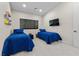 Bedroom with two twin beds, blue bedding, window with shade, and television at 3104 Conners Dr, Las Vegas, NV 89107
