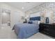 Comfortable bedroom showcasing blue bedding, modern nightstands, and a view into the ensuite bathroom at 3104 Conners Dr, Las Vegas, NV 89107