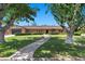 Attractive single-story brick home showcasing a well-manicured lawn, mature trees, and inviting curb appeal at 3104 Conners Dr, Las Vegas, NV 89107