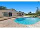 Beautiful pool with brick surround, lush landscaping, and a view of the main house at 3104 Conners Dr, Las Vegas, NV 89107