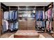 Organized walk-in closet with custom shelving, hanging rods, drawers, and a tufted ottoman at 3104 Conners Dr, Las Vegas, NV 89107