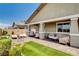 Serene backyard with a covered patio, cozy seating, a lush green lawn, and mature trees, ideal for outdoor living at 348 Cadence Vista Dr, Henderson, NV 89011