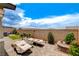 Private backyard with a covered patio, brick pavers, comfortable lounge chairs, and colorful flowers, designed for relaxation at 348 Cadence Vista Dr, Henderson, NV 89011