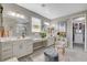 Stylish bathroom with double sinks, modern lighting, and access to a spacious walk-in closet at 348 Cadence Vista Dr, Henderson, NV 89011