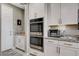 Modern kitchen features stainless steel appliances, including a double oven, granite countertops, and white cabinets at 348 Cadence Vista Dr, Henderson, NV 89011
