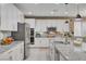 Bright kitchen featuring a large island with white cabinets, granite countertops, and stainless steel appliances at 348 Cadence Vista Dr, Henderson, NV 89011