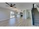 Open floorplan shows kitchen, living room, and stairs with wood-look floors and natural light at 3484 Nightflower Ln # B, Las Vegas, NV 89121