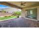 Comfortable covered back patio with brick flooring and a serene view of the landscaped backyard at 3486 Molinos Dr, Las Vegas, NV 89141