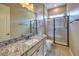 Bathroom vanity featuring granite countertop, a large mirror, tile floors, and a shower at 3486 Molinos Dr, Las Vegas, NV 89141