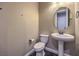 Modern powder room features a pedestal sink, toilet, and neutral walls at 3486 Molinos Dr, Las Vegas, NV 89141