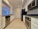 Galley-style kitchen with stainless steel appliances, stone counters, and an open design to living area at 38 E Serene Ave # 432, Las Vegas, NV 89123