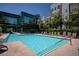 A beautiful community swimming pool surrounded by lounge chairs, set against modern glass architecture at 38 E Serene Ave # 432, Las Vegas, NV 89123